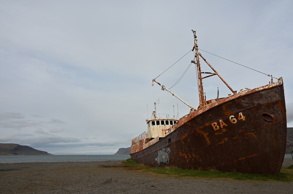 a rusted boat sitting on top of a beach