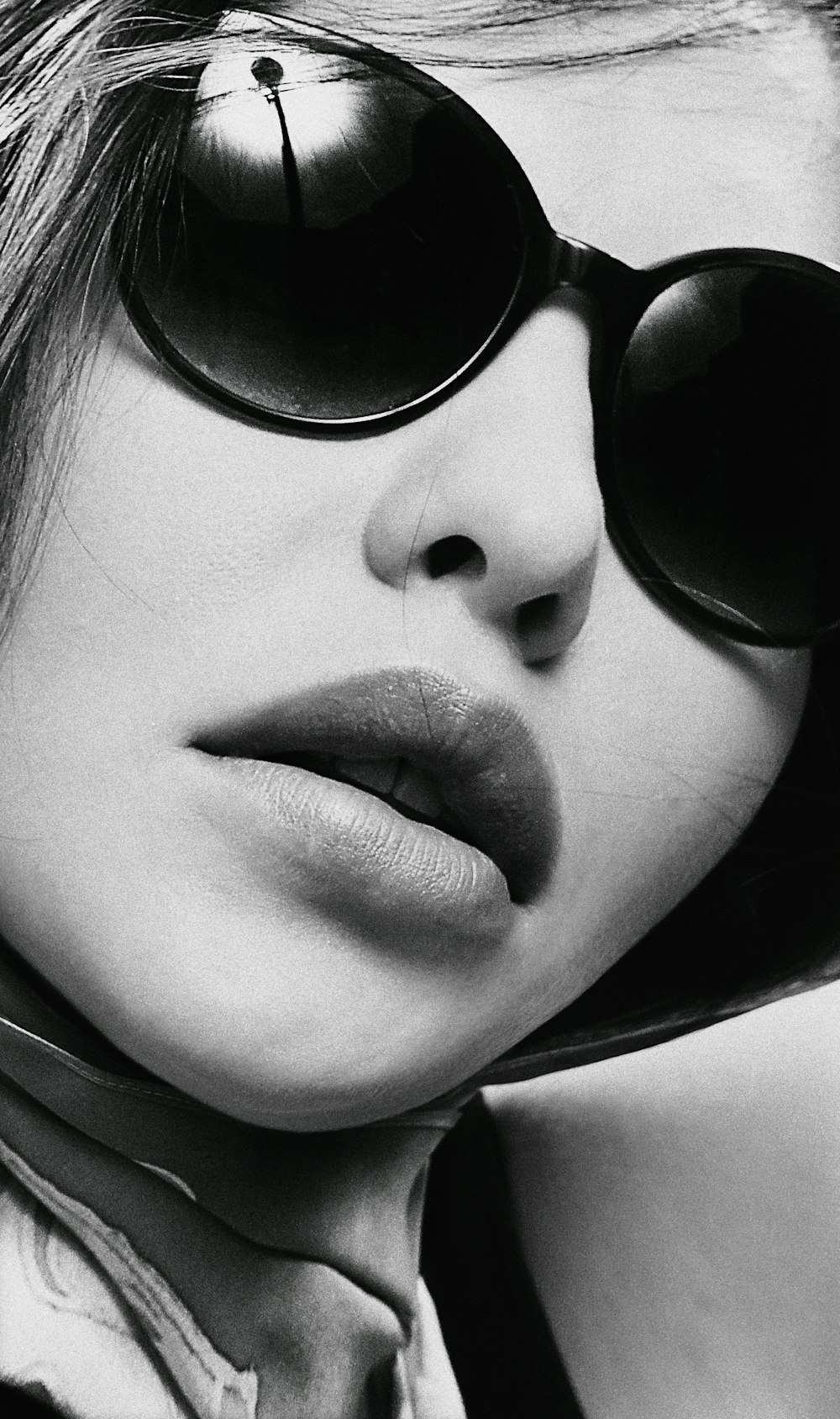 Una foto en blanco y negro de una mujer con gafas de sol