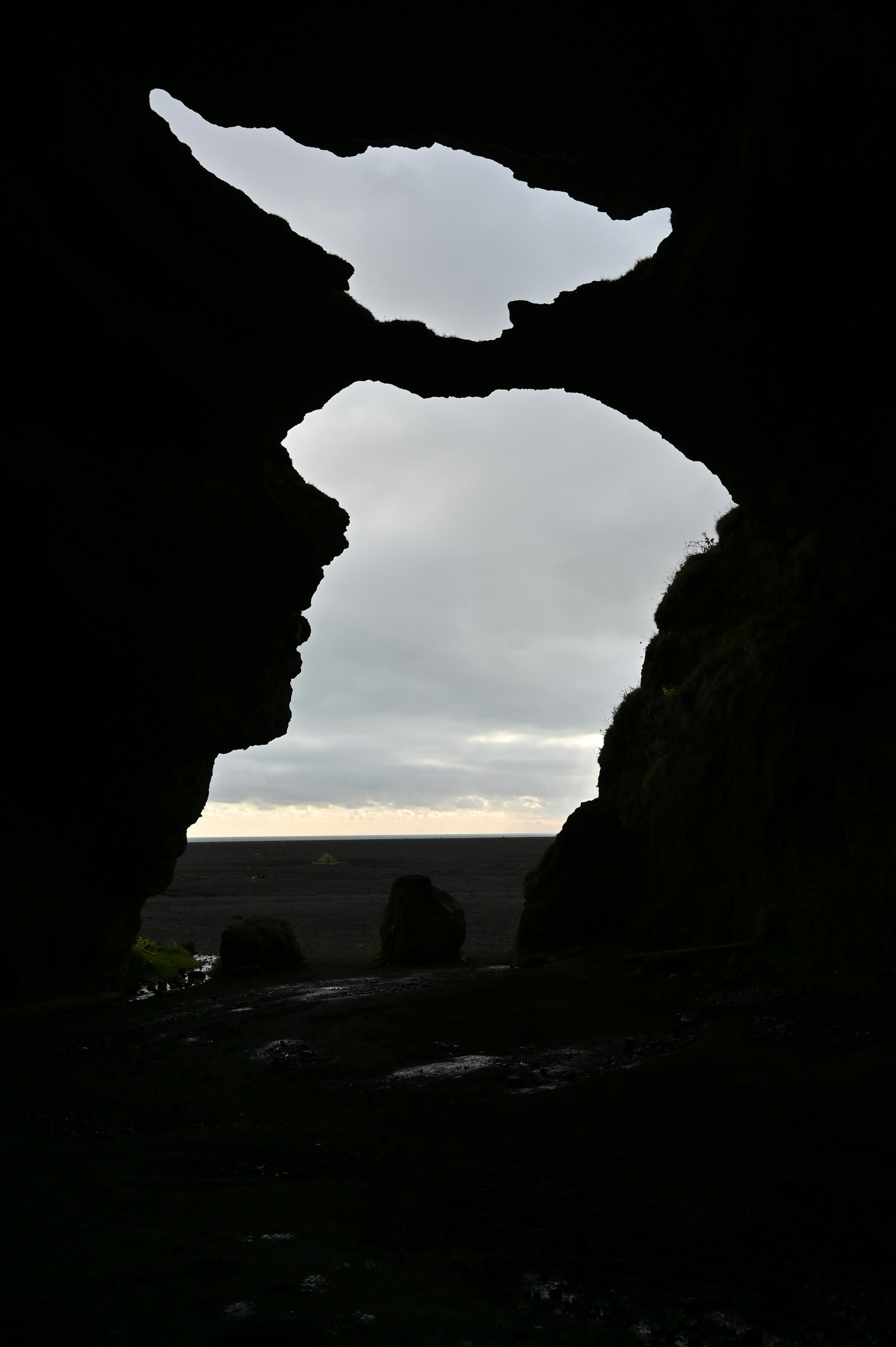 a dark cave with a view of the ocean