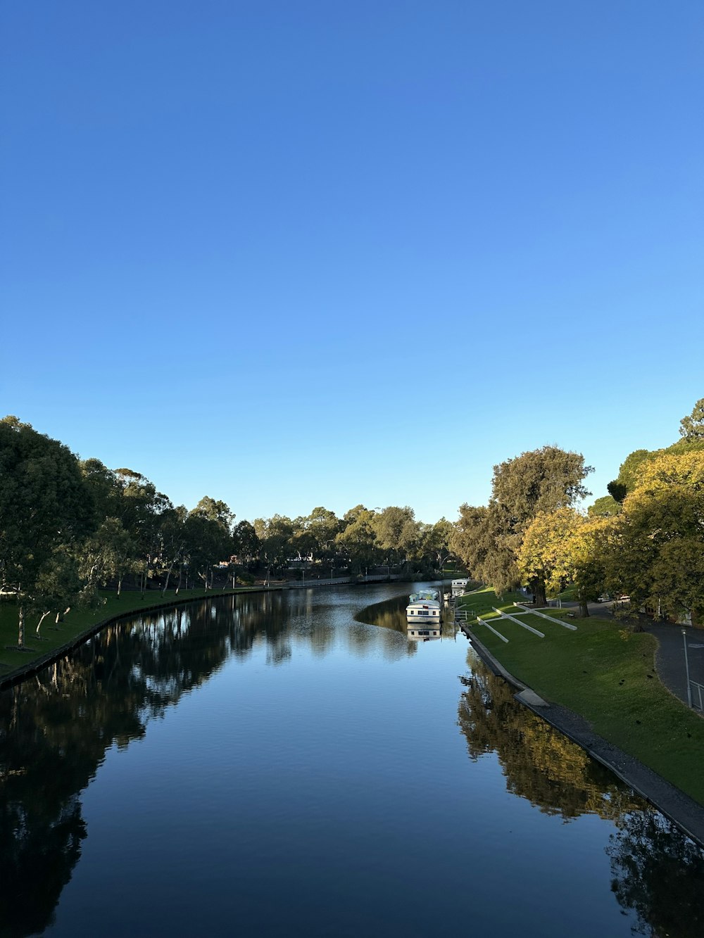 a body of water surrounded by trees and grass