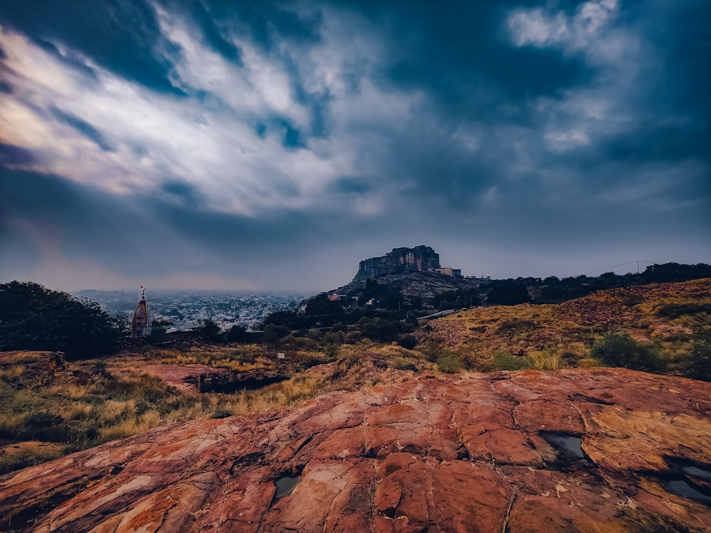 a rocky outcropping with a castle in the distance