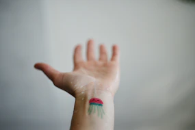 a hand with a jellyfish tattoo on it