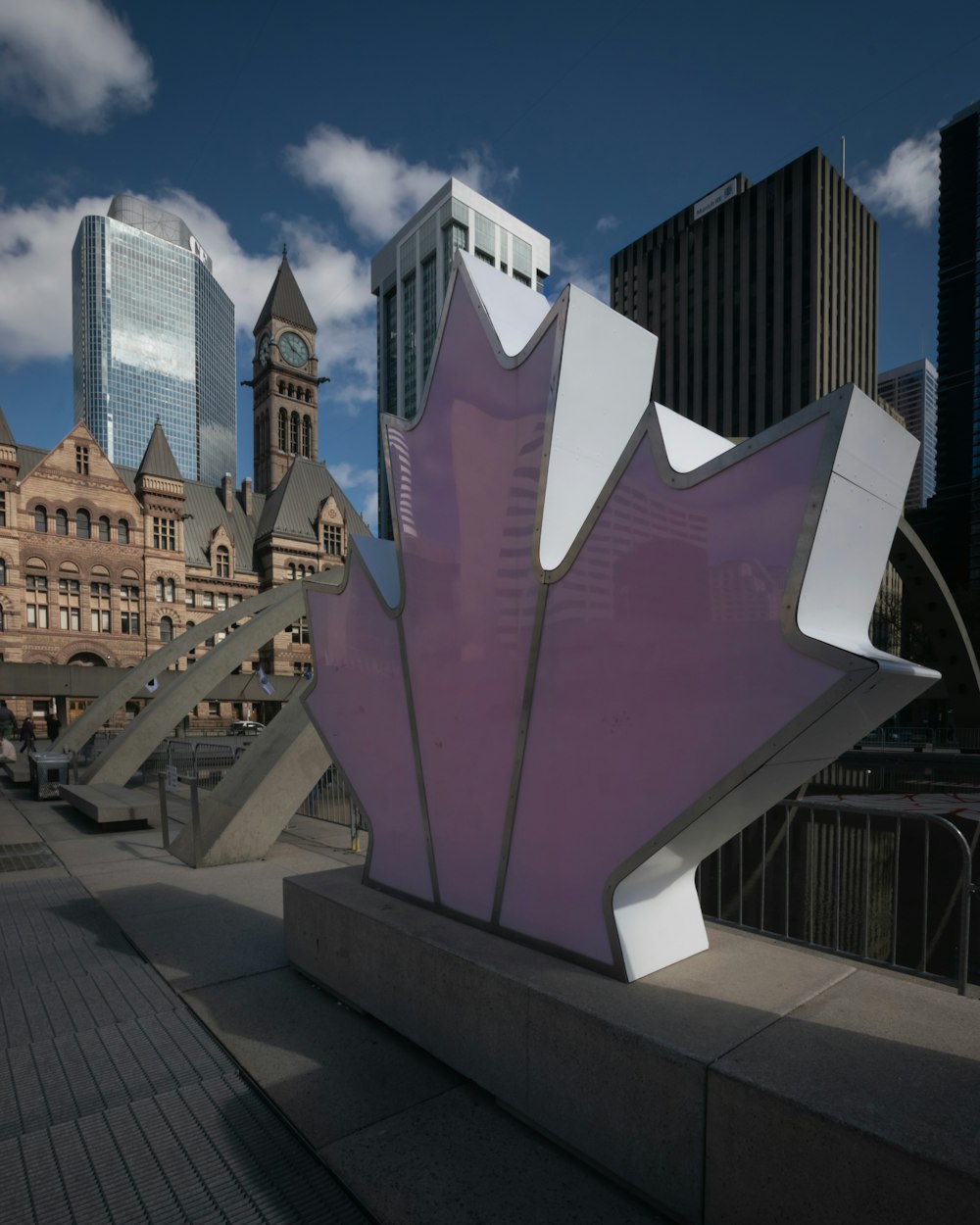 a sculpture of a purple flower in front of a cityscape