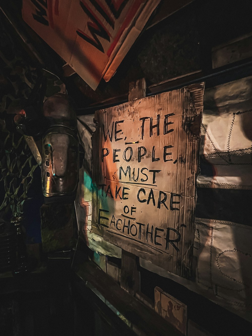 a wooden sign that says we the people must be care of each other