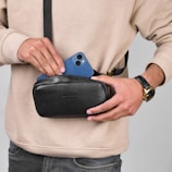 a man holding a black case with a blue phone in it