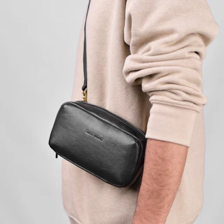 a man is holding a black bag in his hand