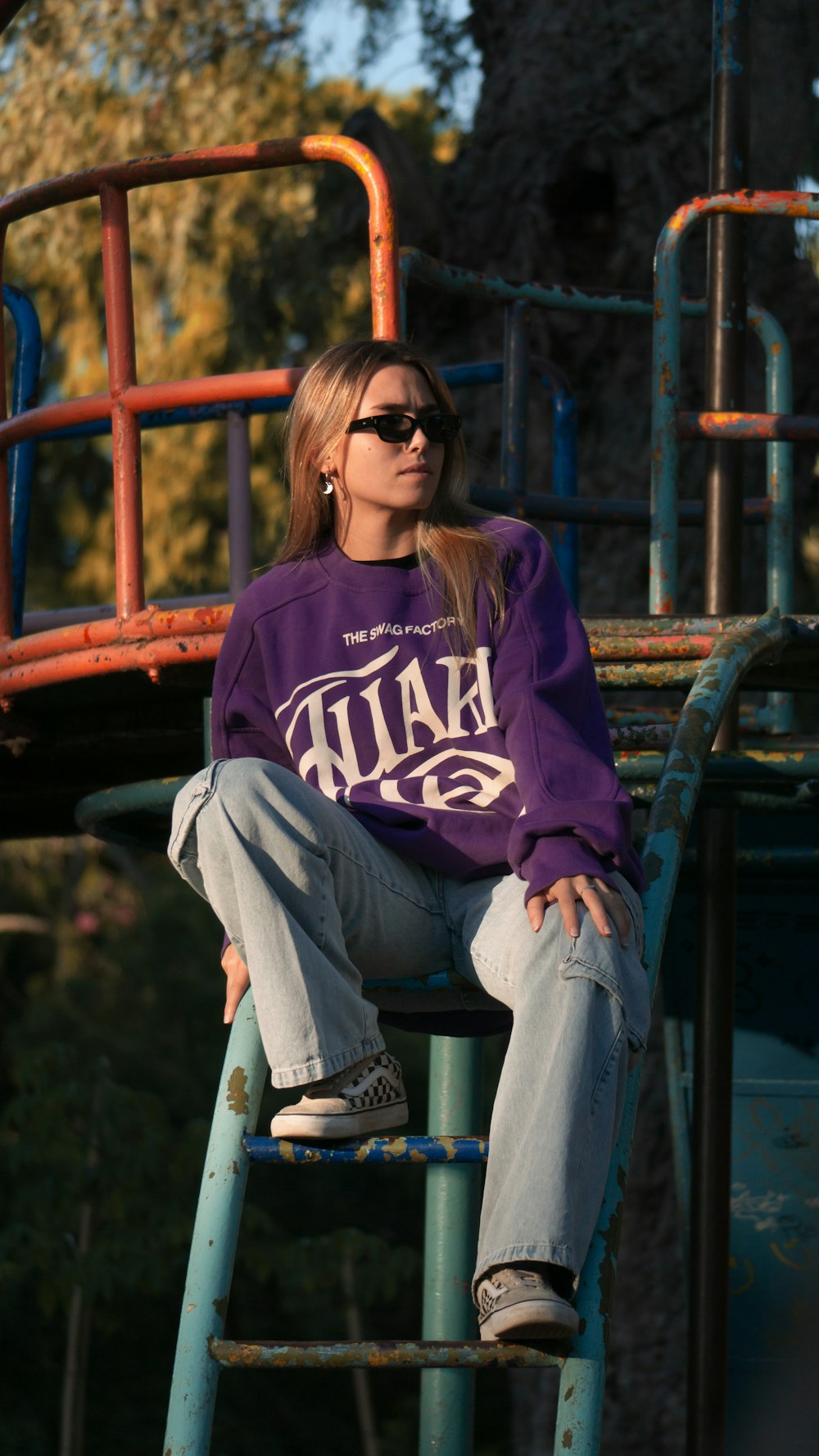 a woman sitting on top of a metal ladder