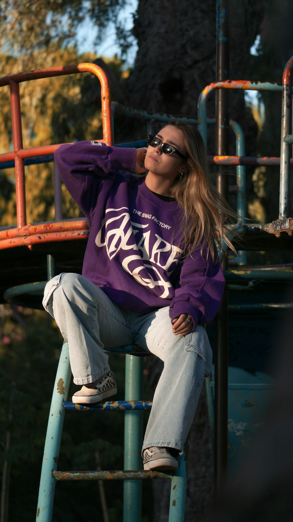 a woman sitting on top of a metal ladder