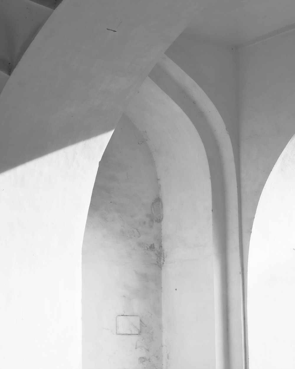 a black and white photo of a room with arches
