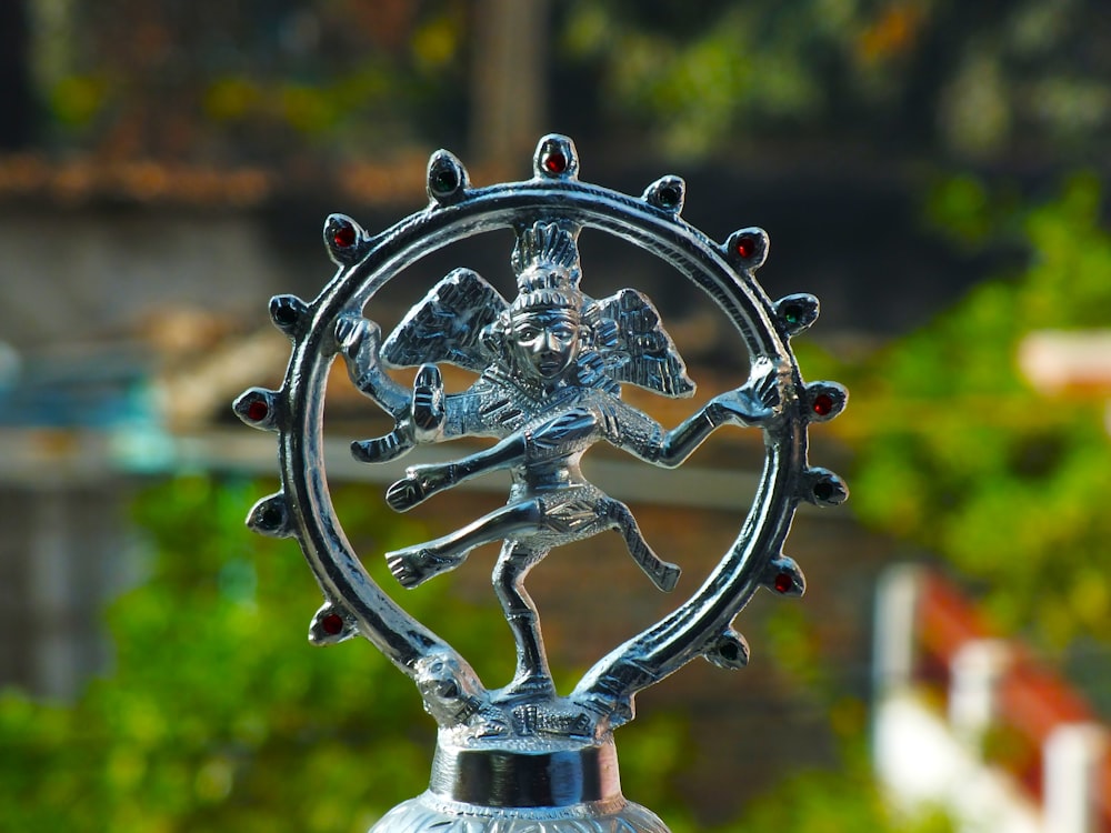 a silver statue of a person holding a ball