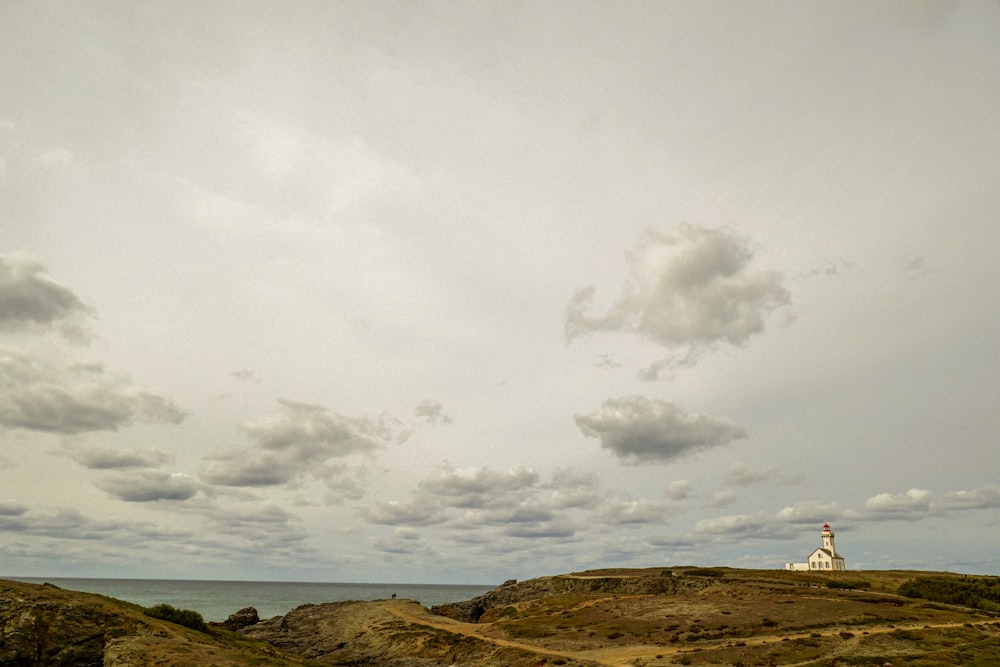 a lighthouse on top of a hill near the ocean