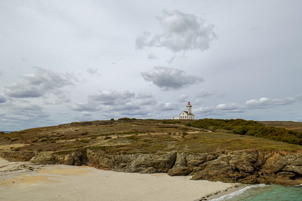 um farol branco no topo de um afloramento rochoso