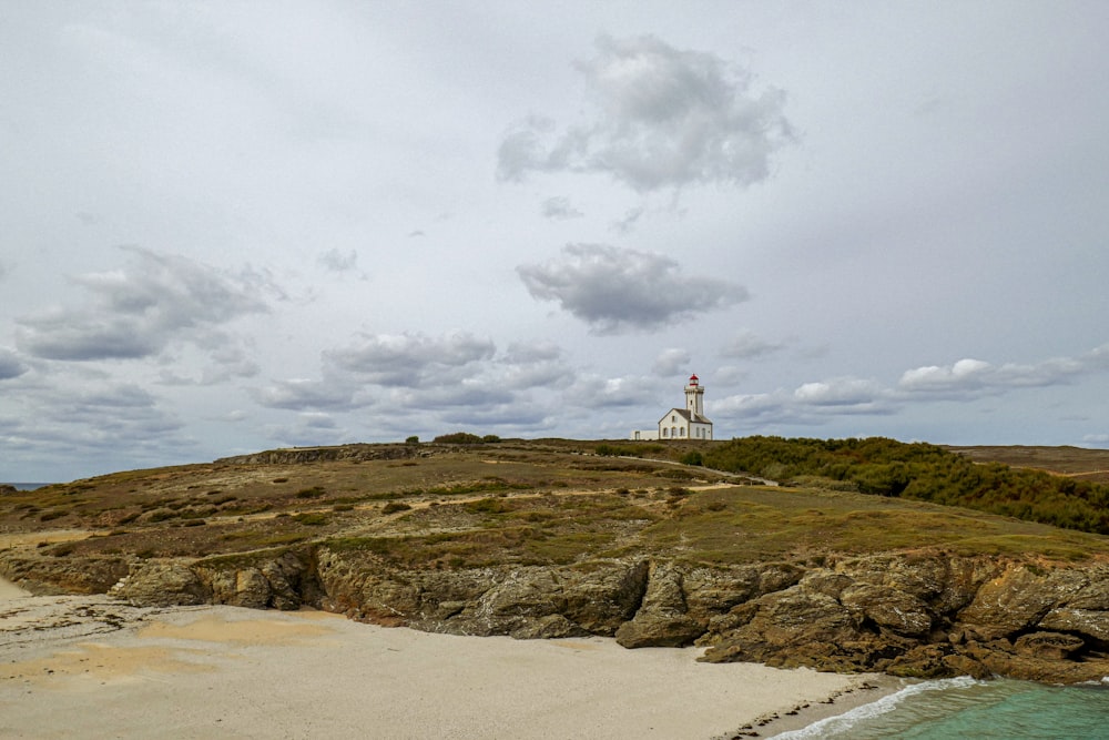 a white lighthouse on top of a rocky outcropping