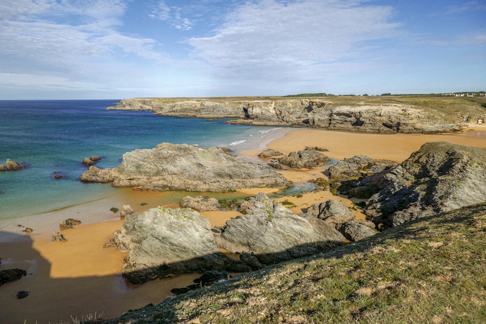 uma praia de areia ao lado do oceano sob um céu azul