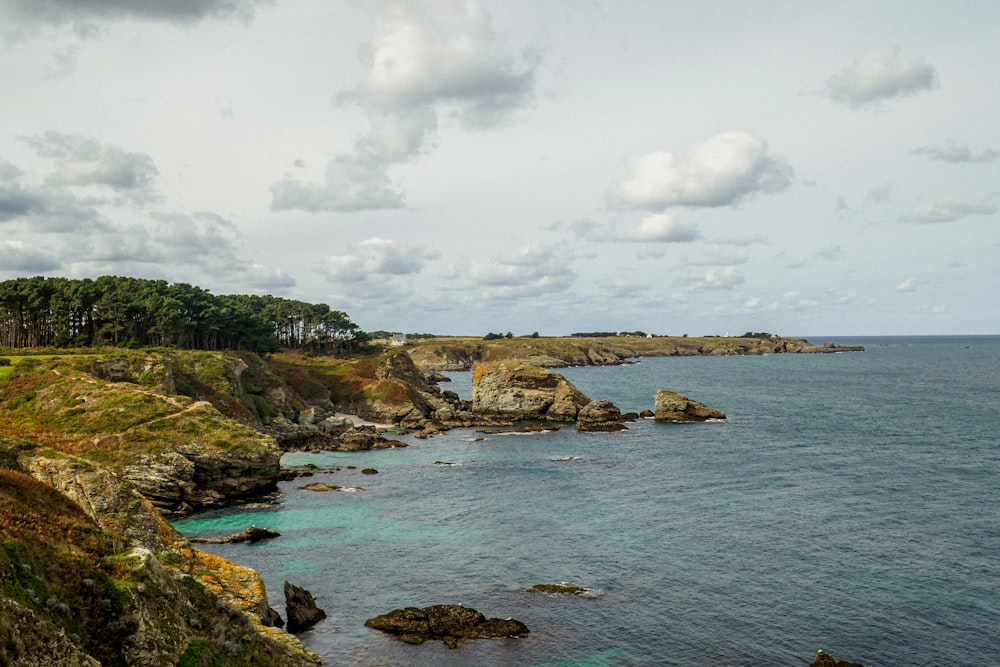 a scenic view of the ocean with a lighthouse in the distance