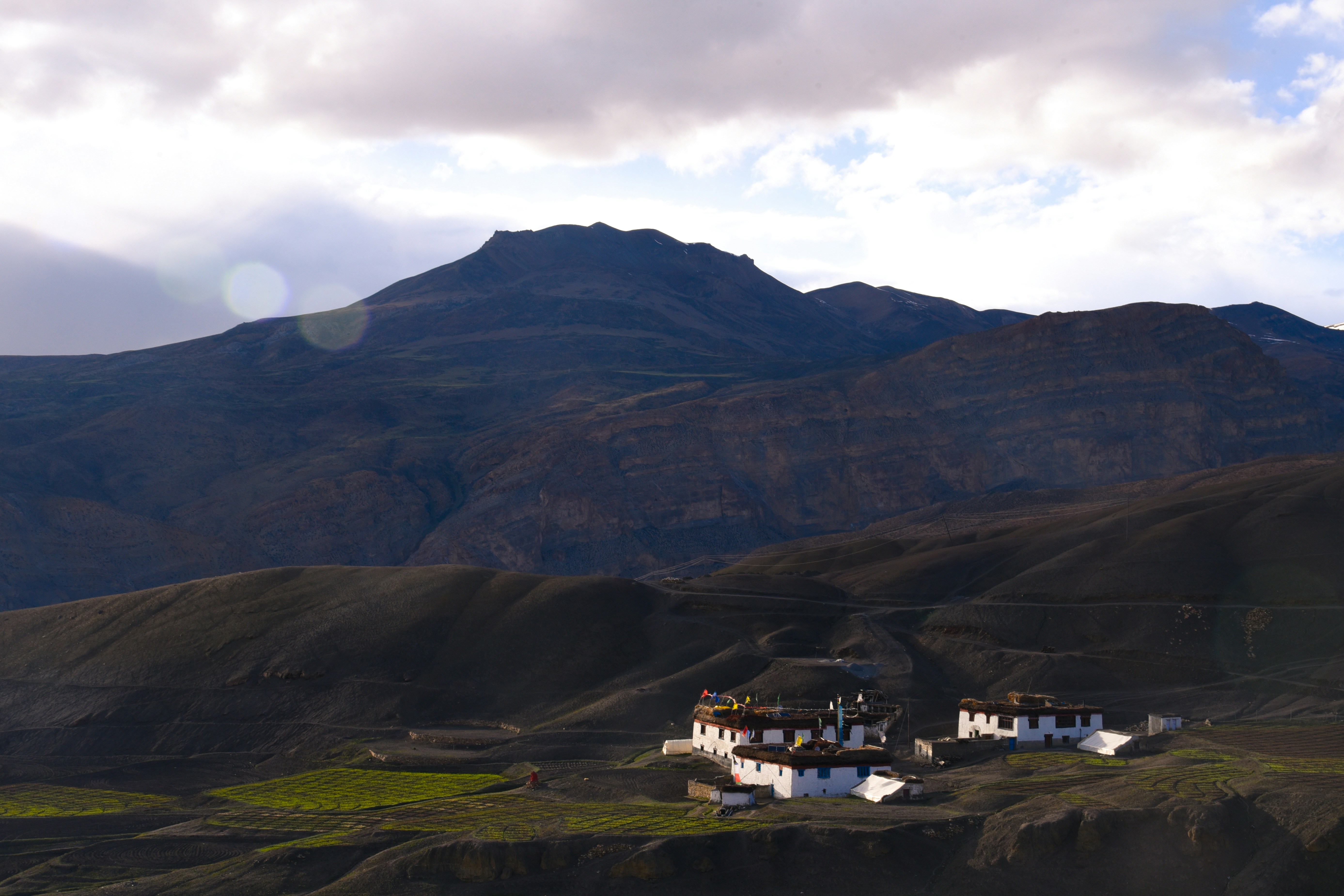 a mountain range with a house in the foreground