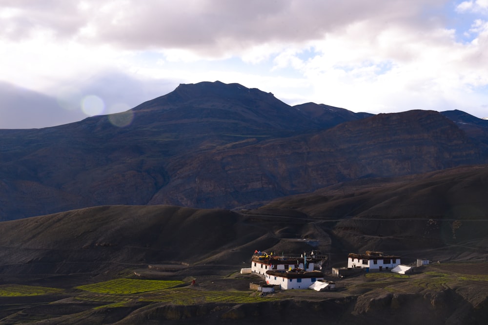 a mountain range with a house in the foreground