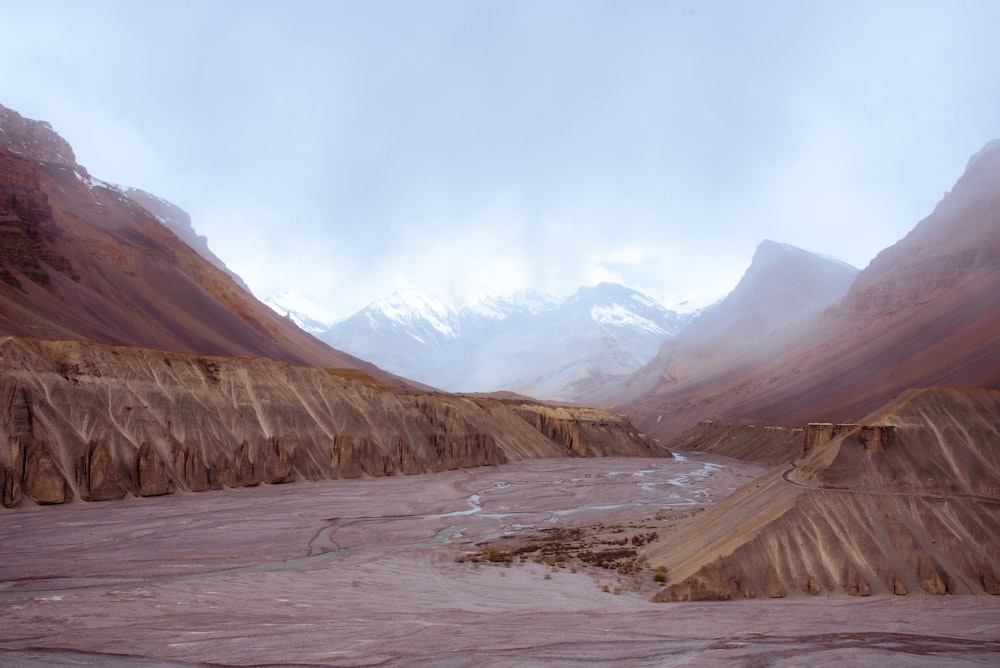 a river flowing through a valley surrounded by mountains