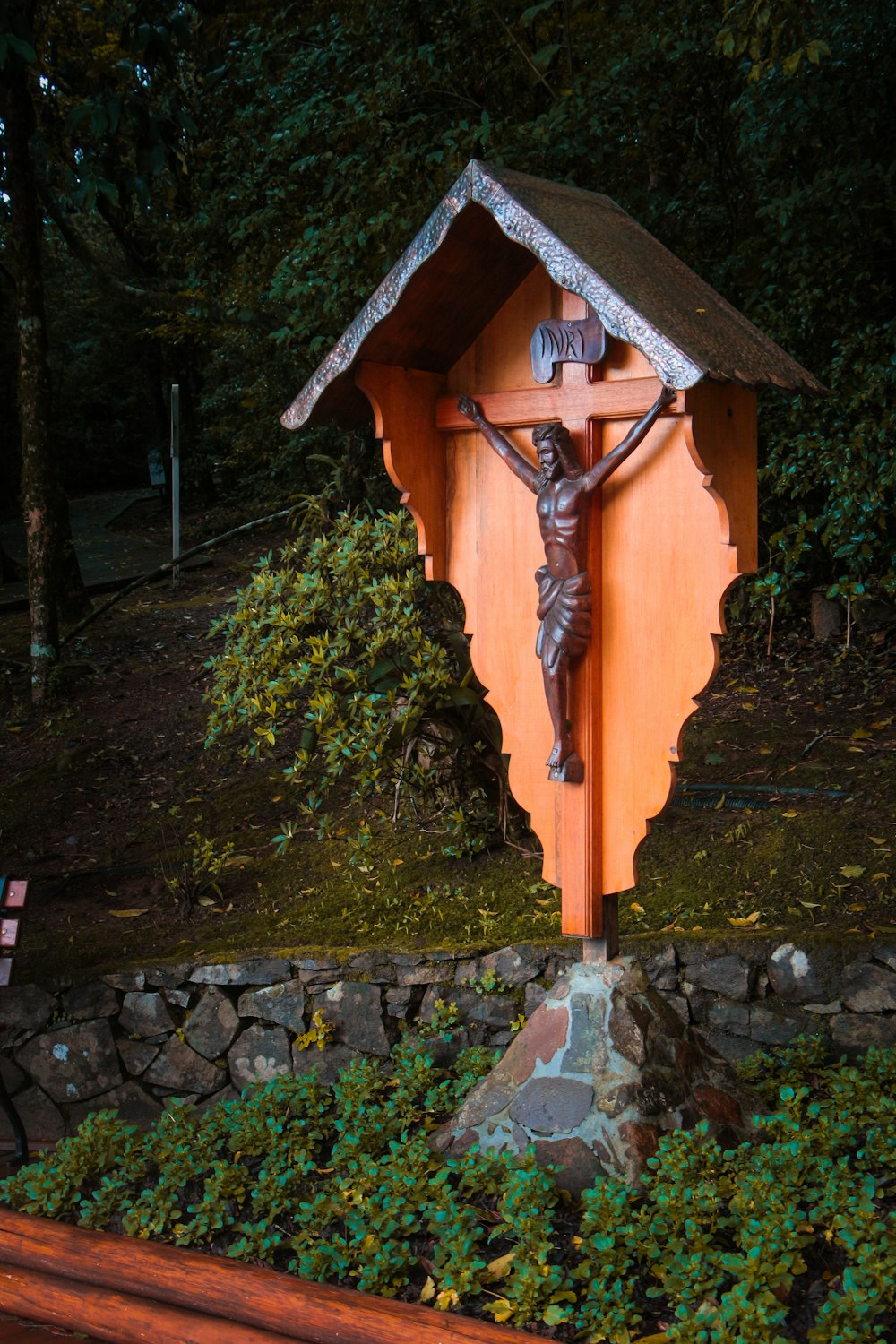 a statue of a crucifix in a garden