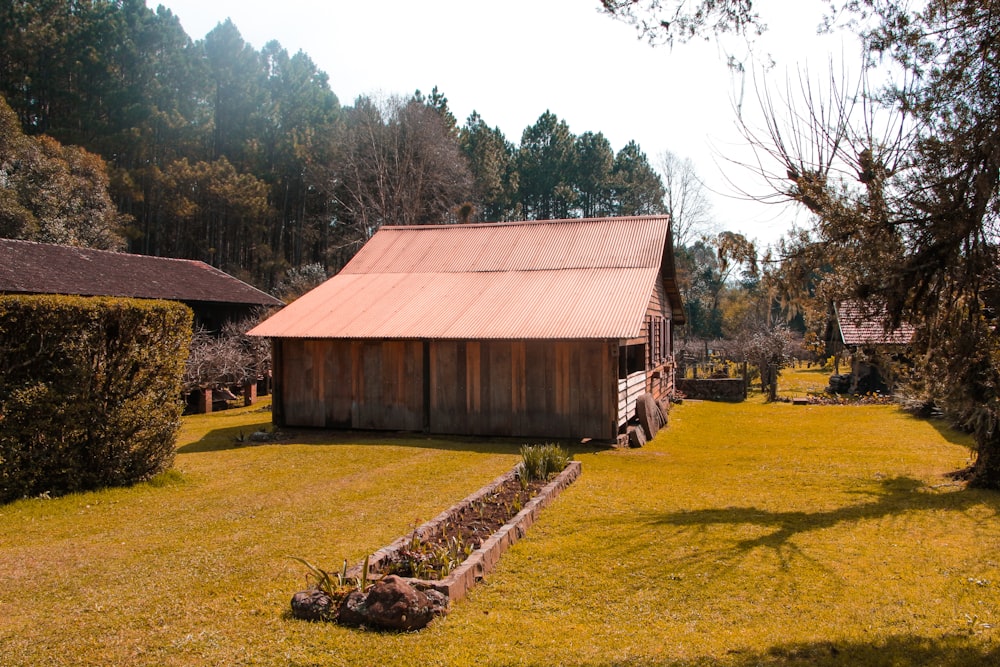 an old log cabin sits in the middle of a field