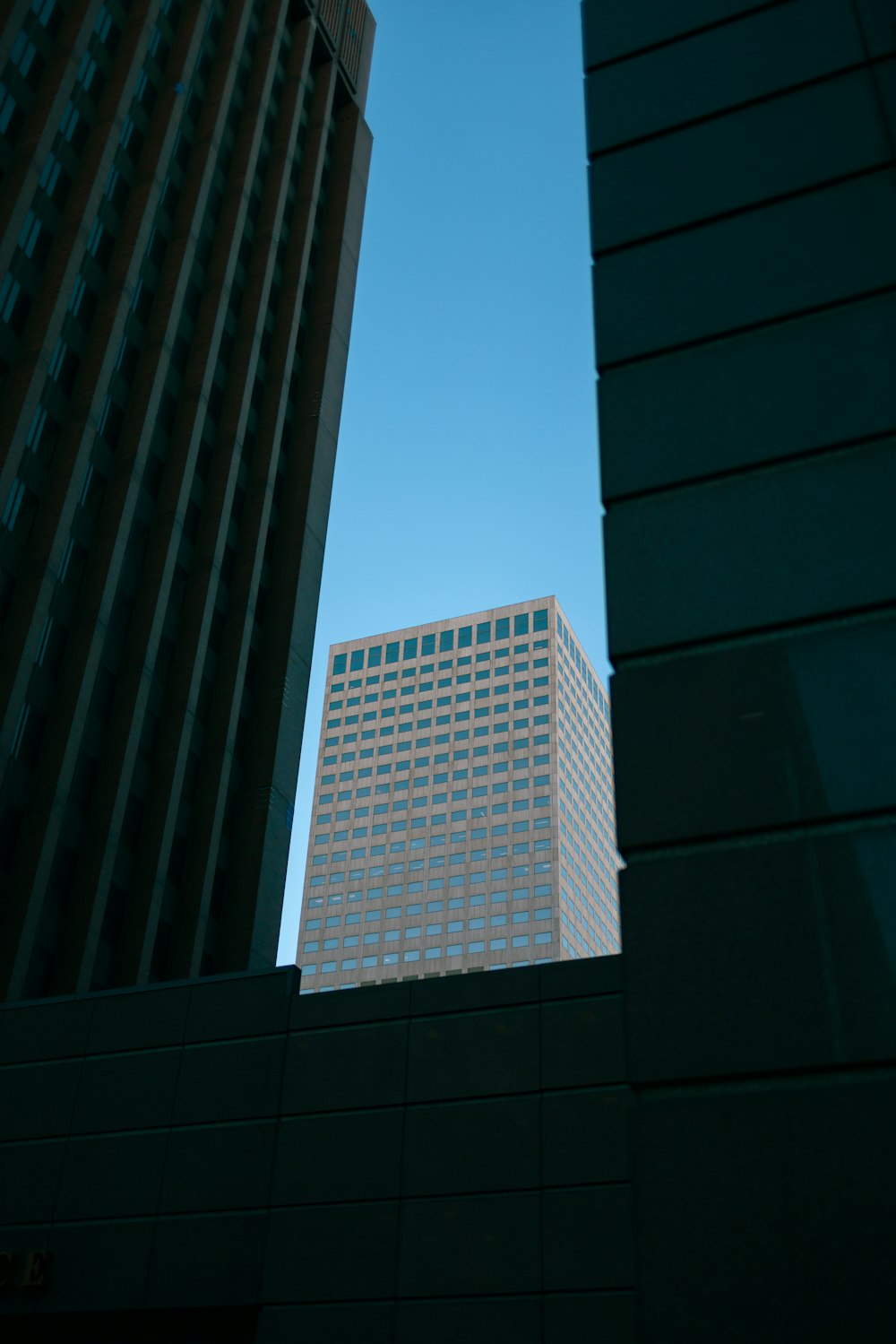 a tall building towering over a city next to other tall buildings