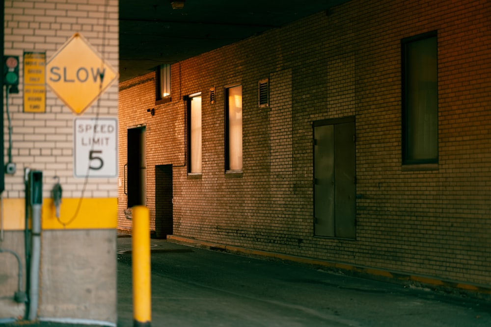 a yellow and white sign sitting on the side of a building