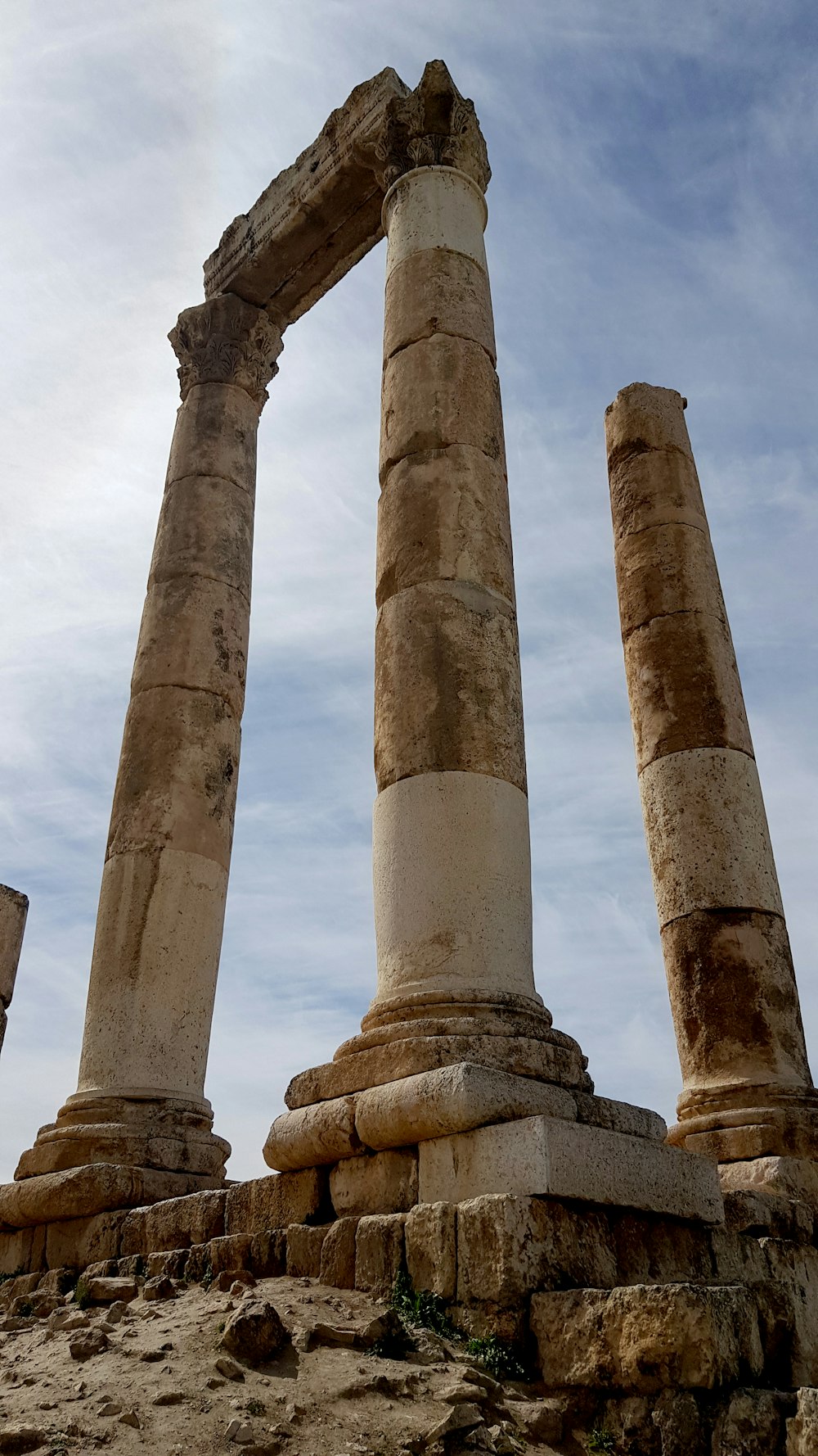 a couple of large stone pillars sitting on top of a dirt field