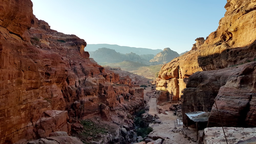 a narrow canyon in the desert with mountains in the background