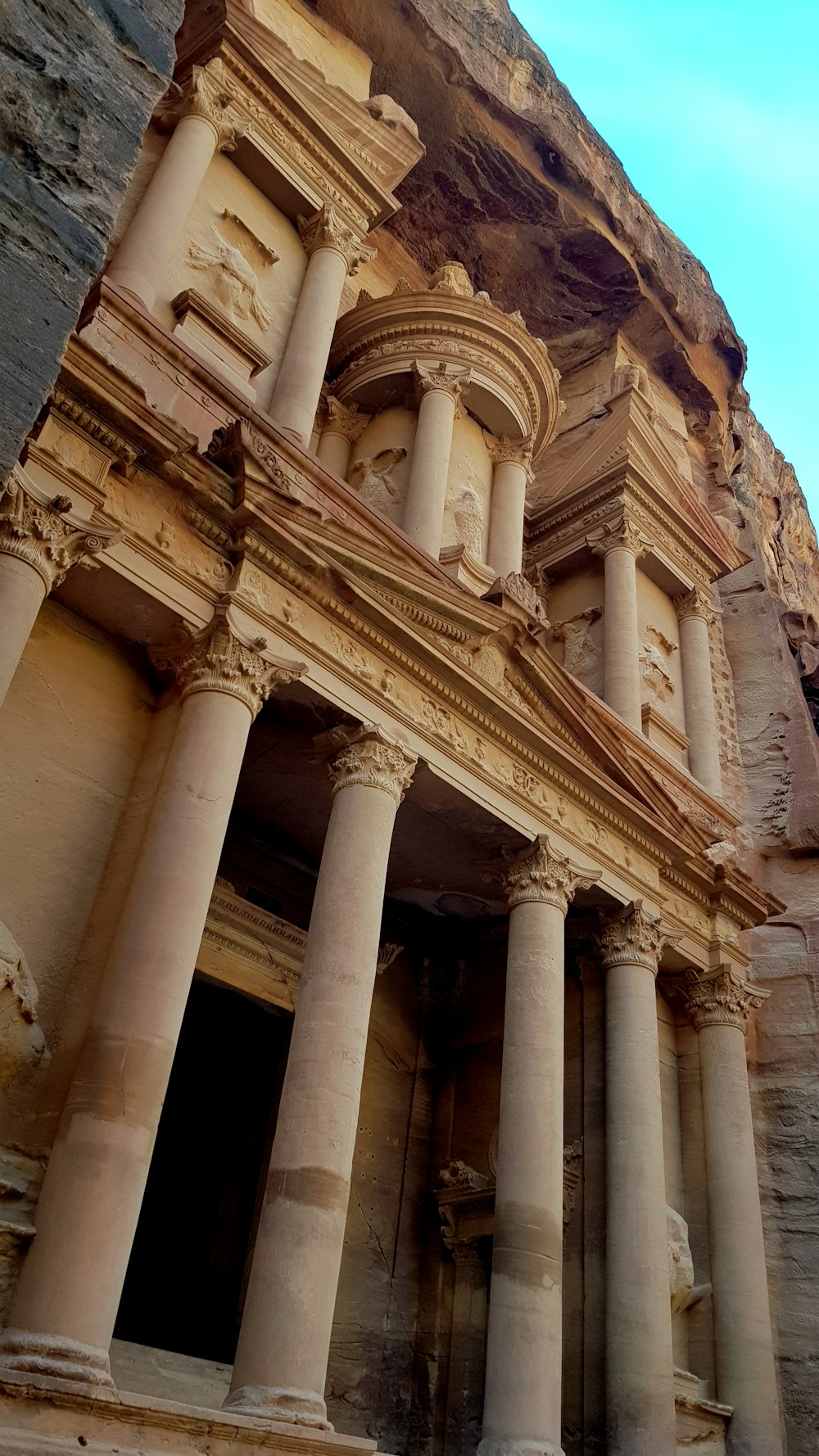 a very tall building with many pillars in front of it