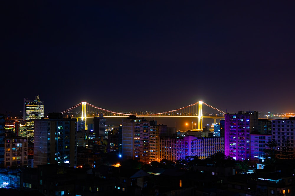 a night view of a city with a bridge in the background