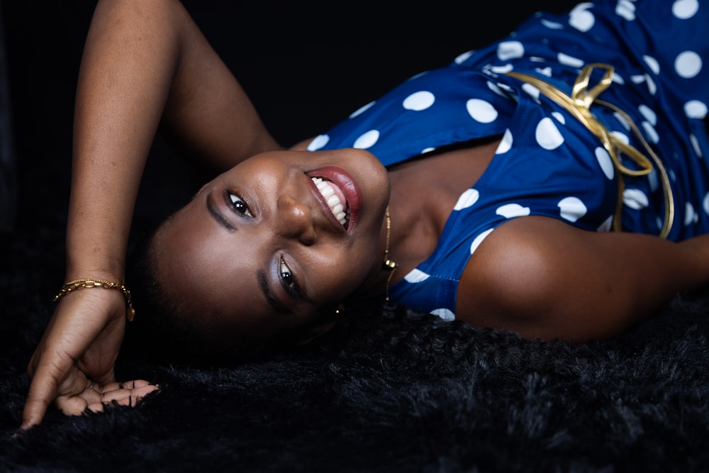 a woman laying on the ground in a blue dress