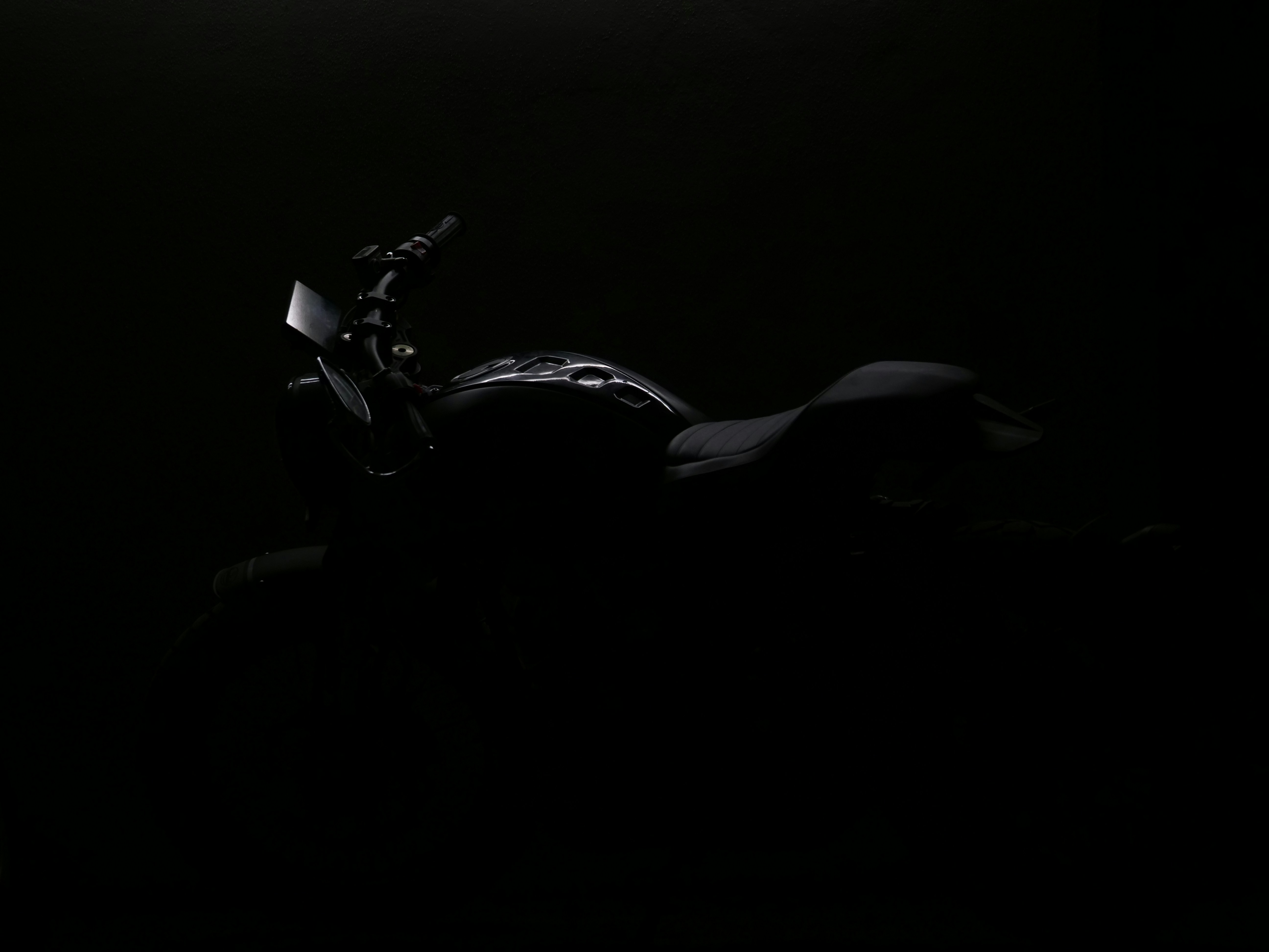 Foto zum Thema Ein Motorrad ist im Dunkeln mit eingeschalteten