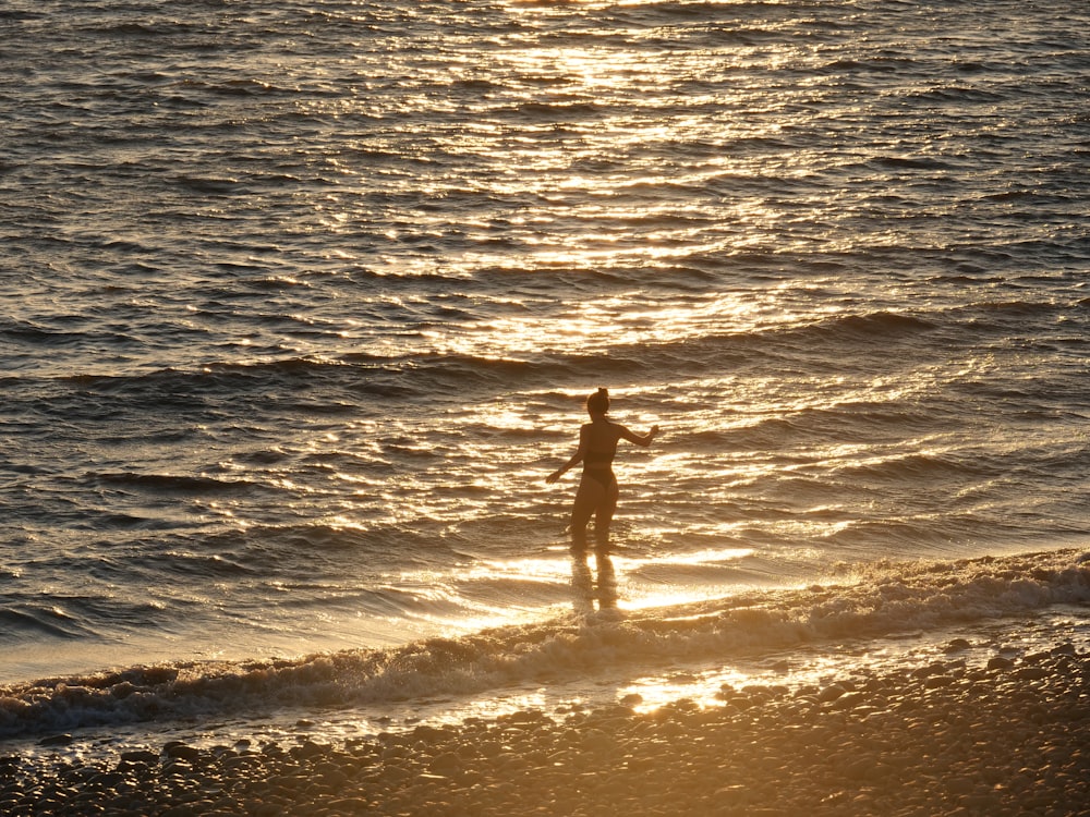una persona de pie sobre una tabla de surf en el océano
