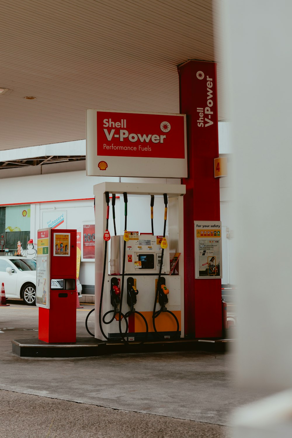 a red and white gas station with a white car