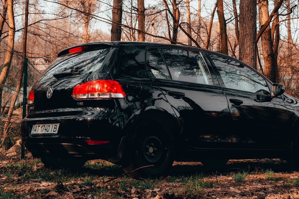 a black car parked in a wooded area