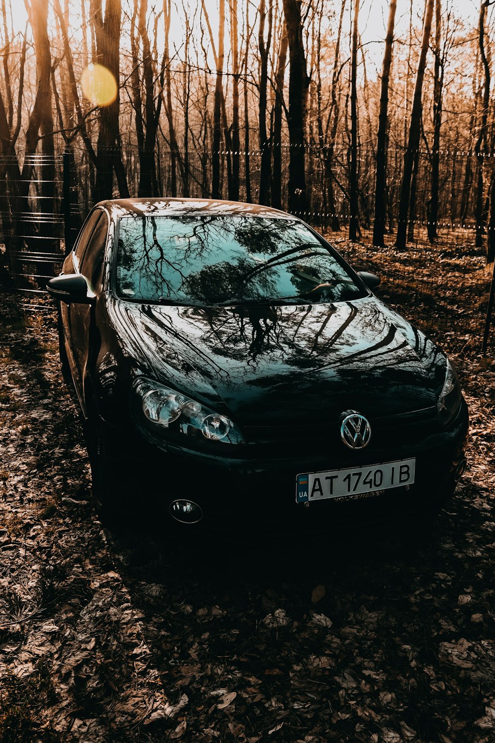 a black car parked in a wooded area
