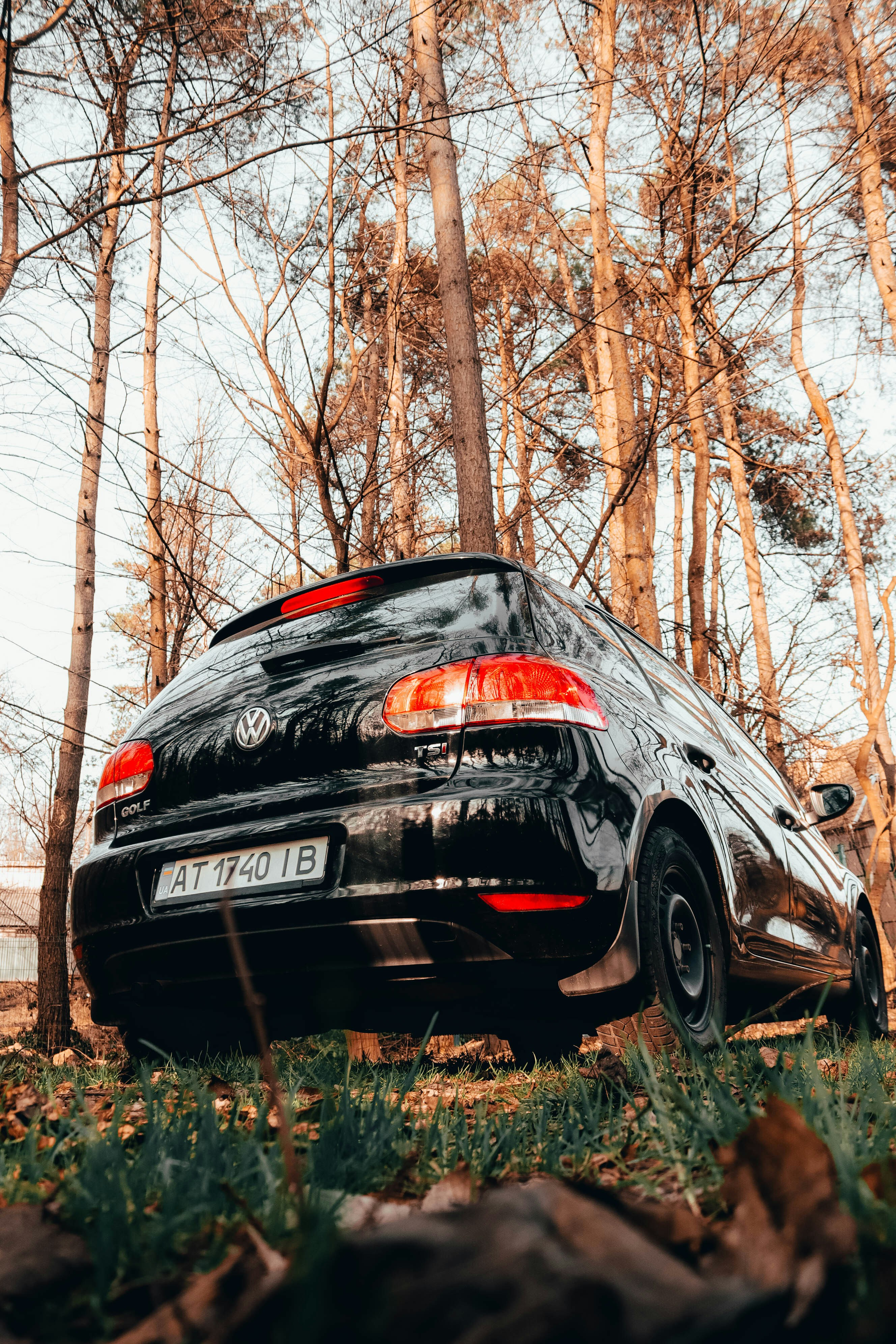 a black car parked in front of some trees