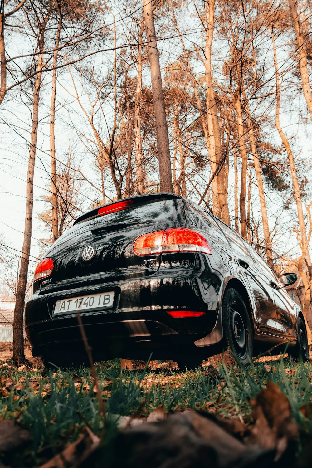 a black car parked in front of some trees