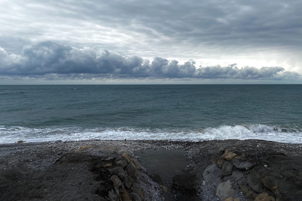 a view of the ocean from a rocky beach