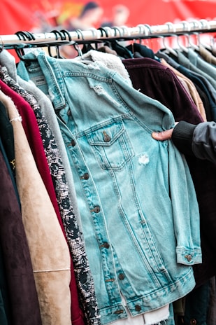 a person holding a jacket on a rack