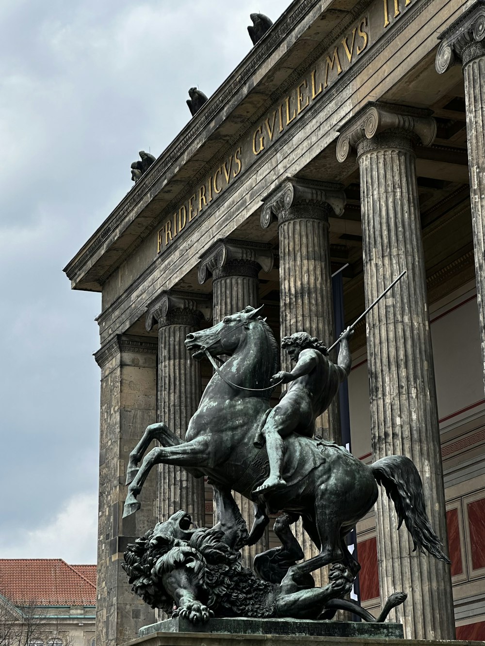 a statue of a man riding a horse in front of a building
