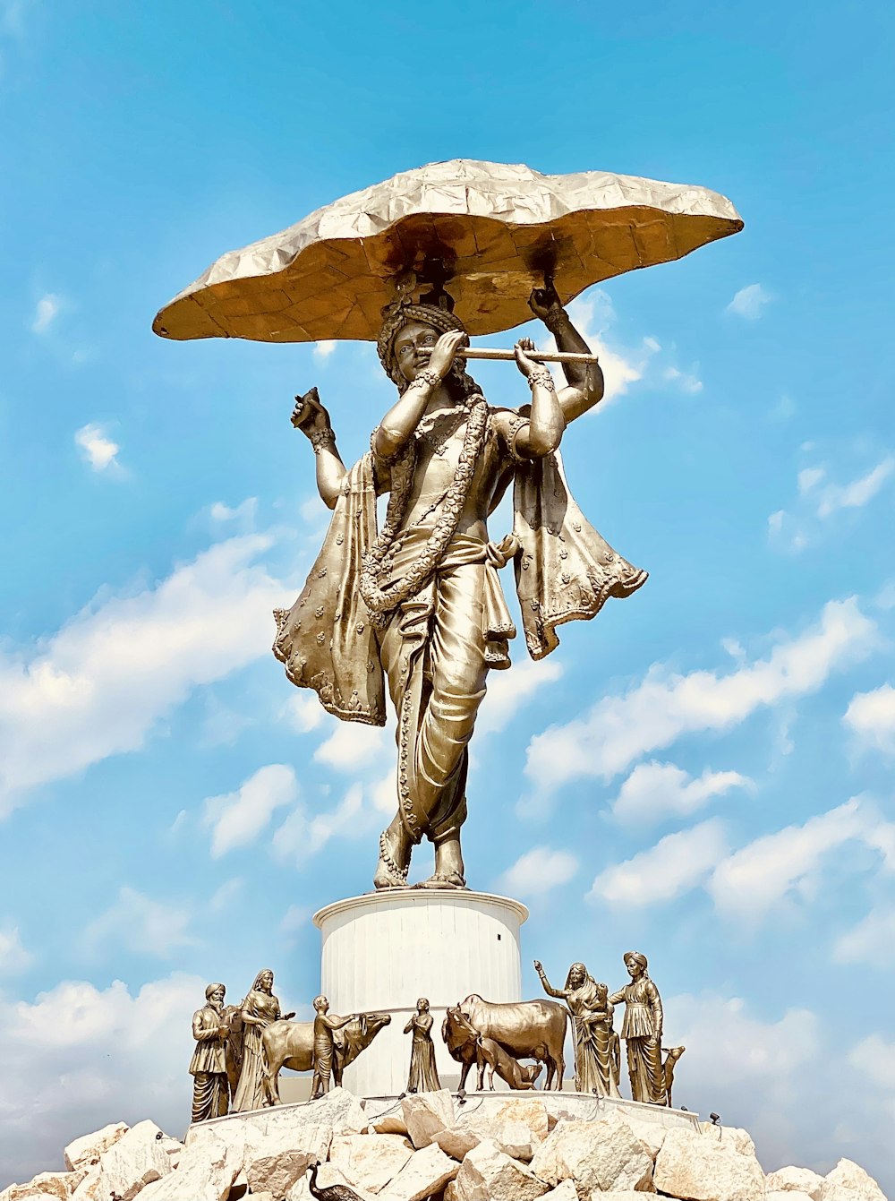 a statue of a woman holding an umbrella over her head