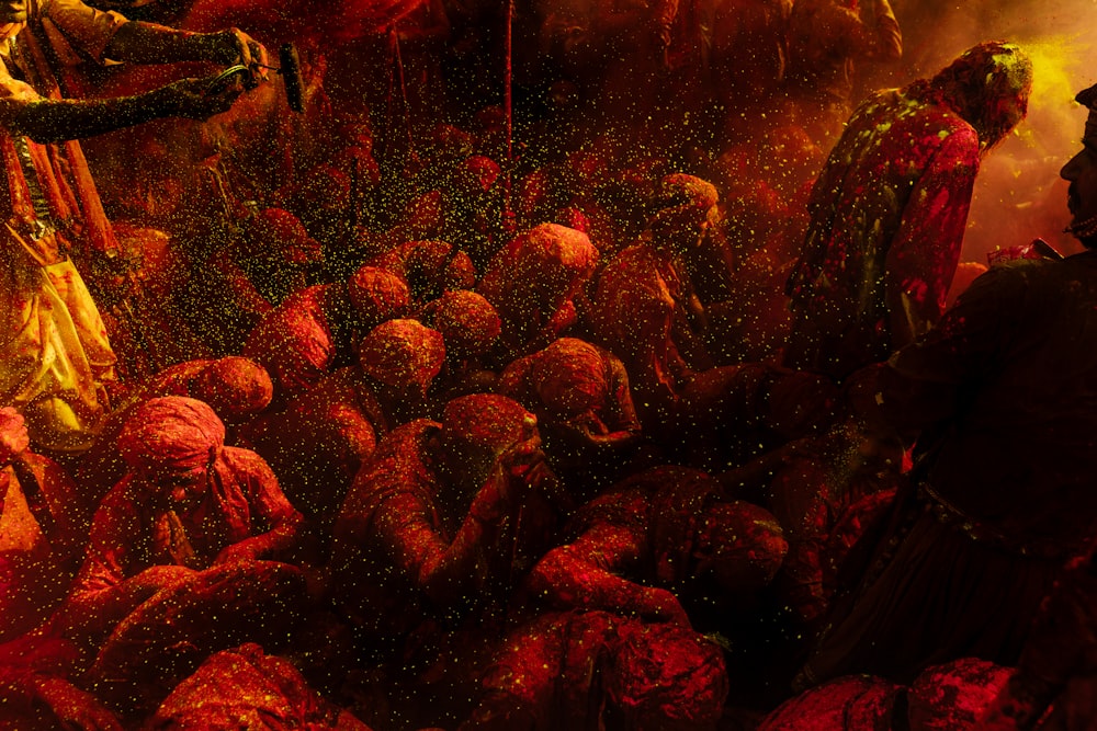 a group of people covered in red and yellow powder