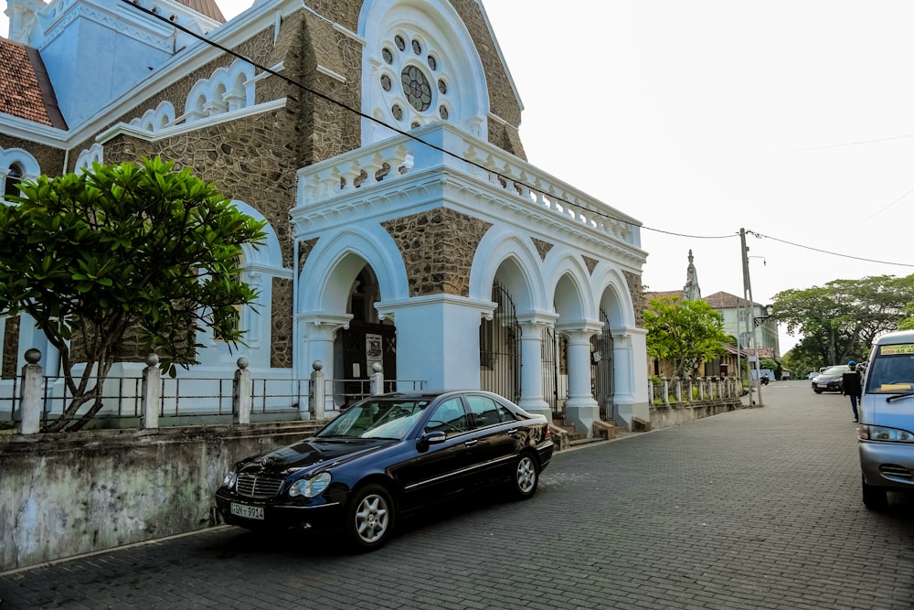 a black car parked in front of a church
