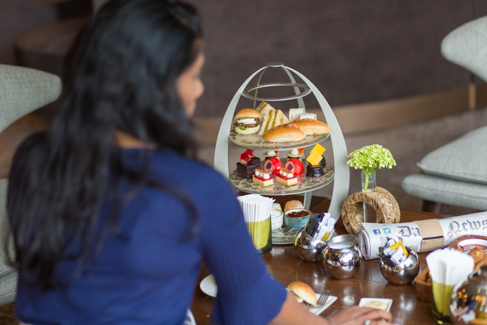 a woman sitting at a table with a tray of food