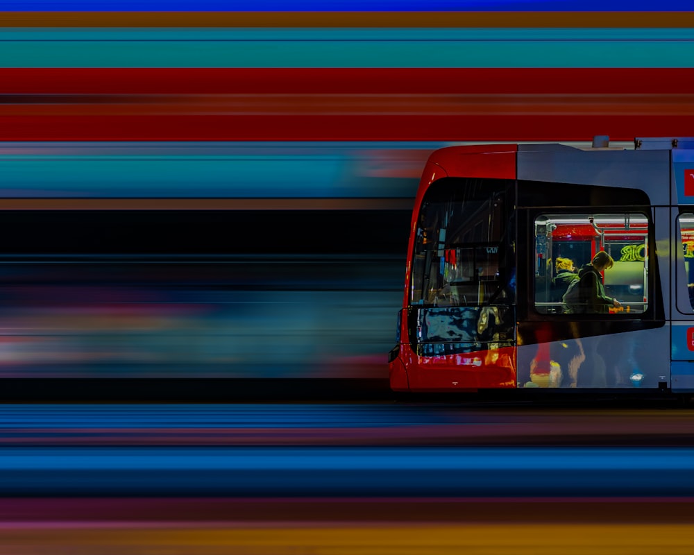 a red and blue bus traveling down a street