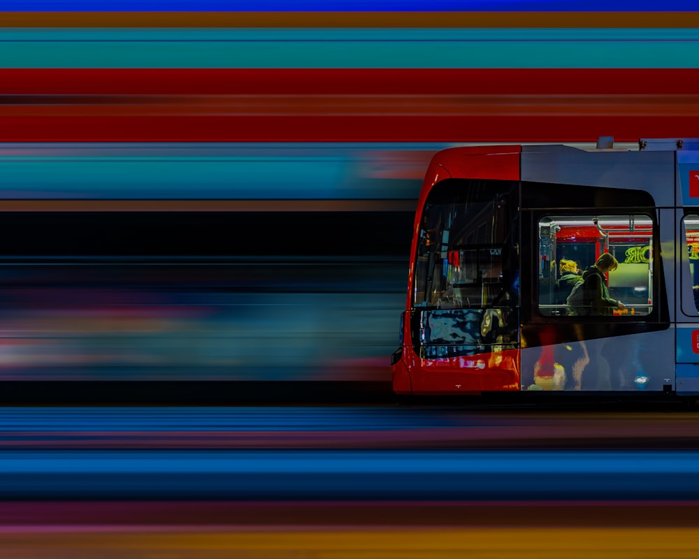 Ein roter und blauer Bus, der eine Straße entlangfährt