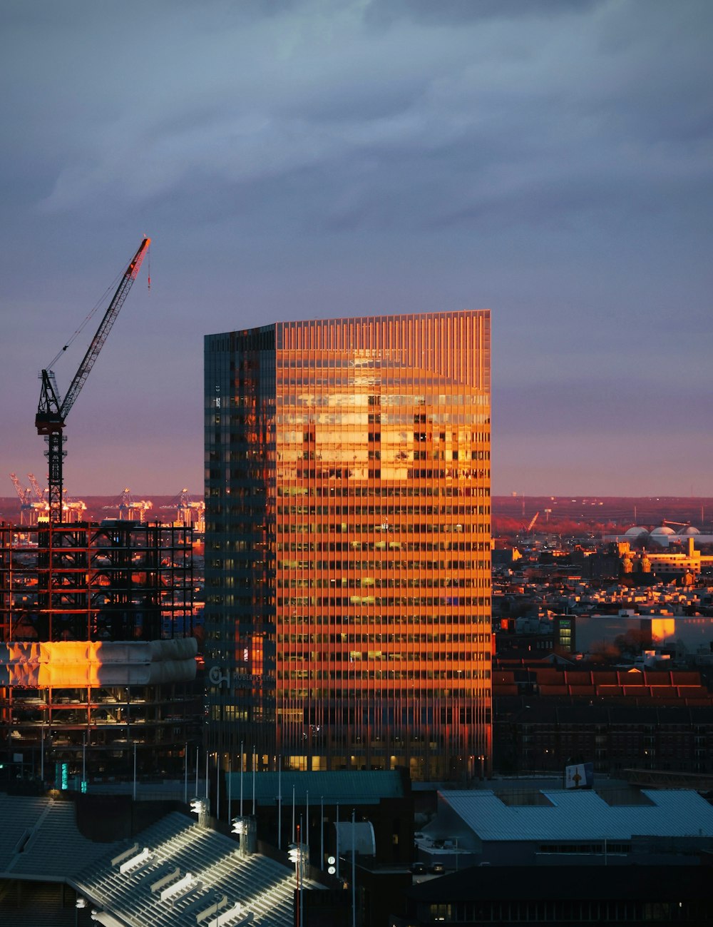 a very tall building with a crane in the background