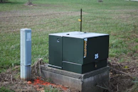 a large green box sitting in the middle of a field