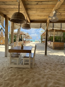 a wooden table sitting under a wooden roof